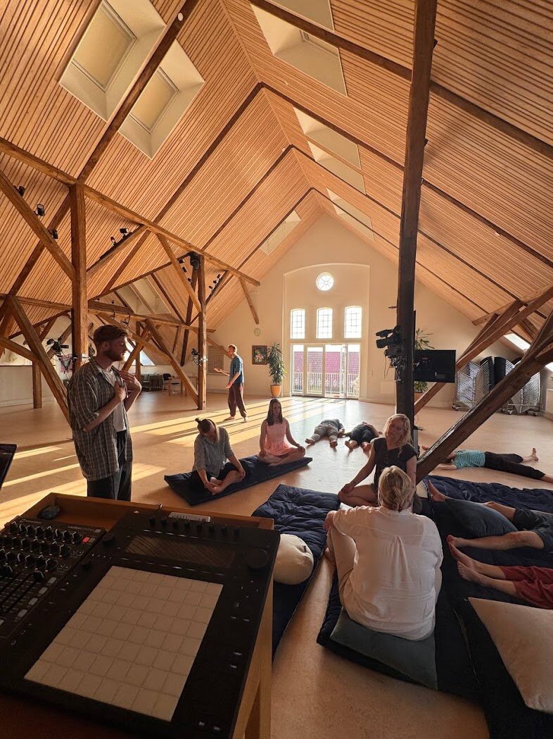 Giel guiding an ecstatic dance session in a timber hall