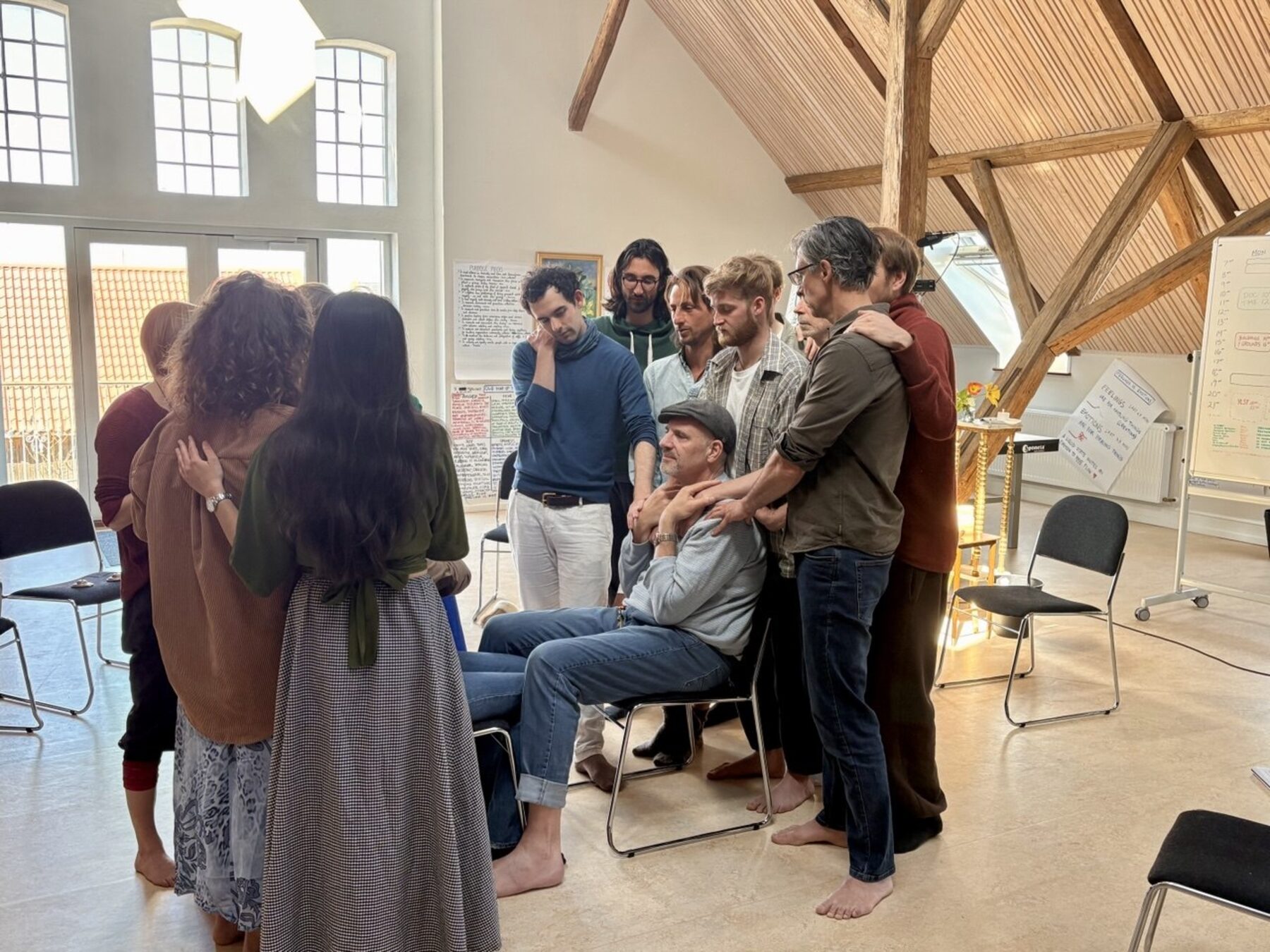 A group holding one man in the middle of a workshop space